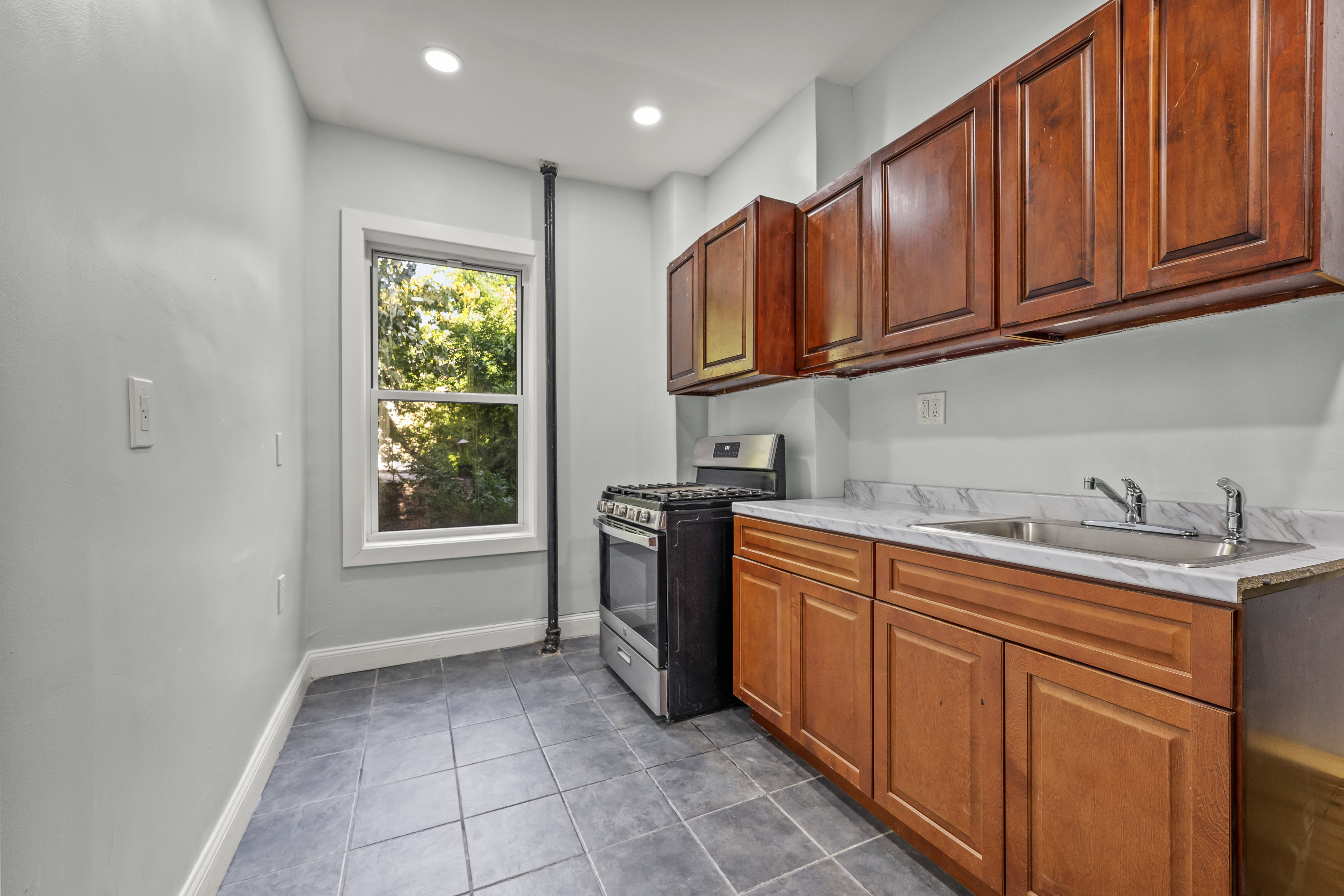 2023 Hughes Avenue Bronx, NY 10457 - Photo 4 of 63 a kitchen with stainless steel appliances granite countertop a sink stove and cabinets