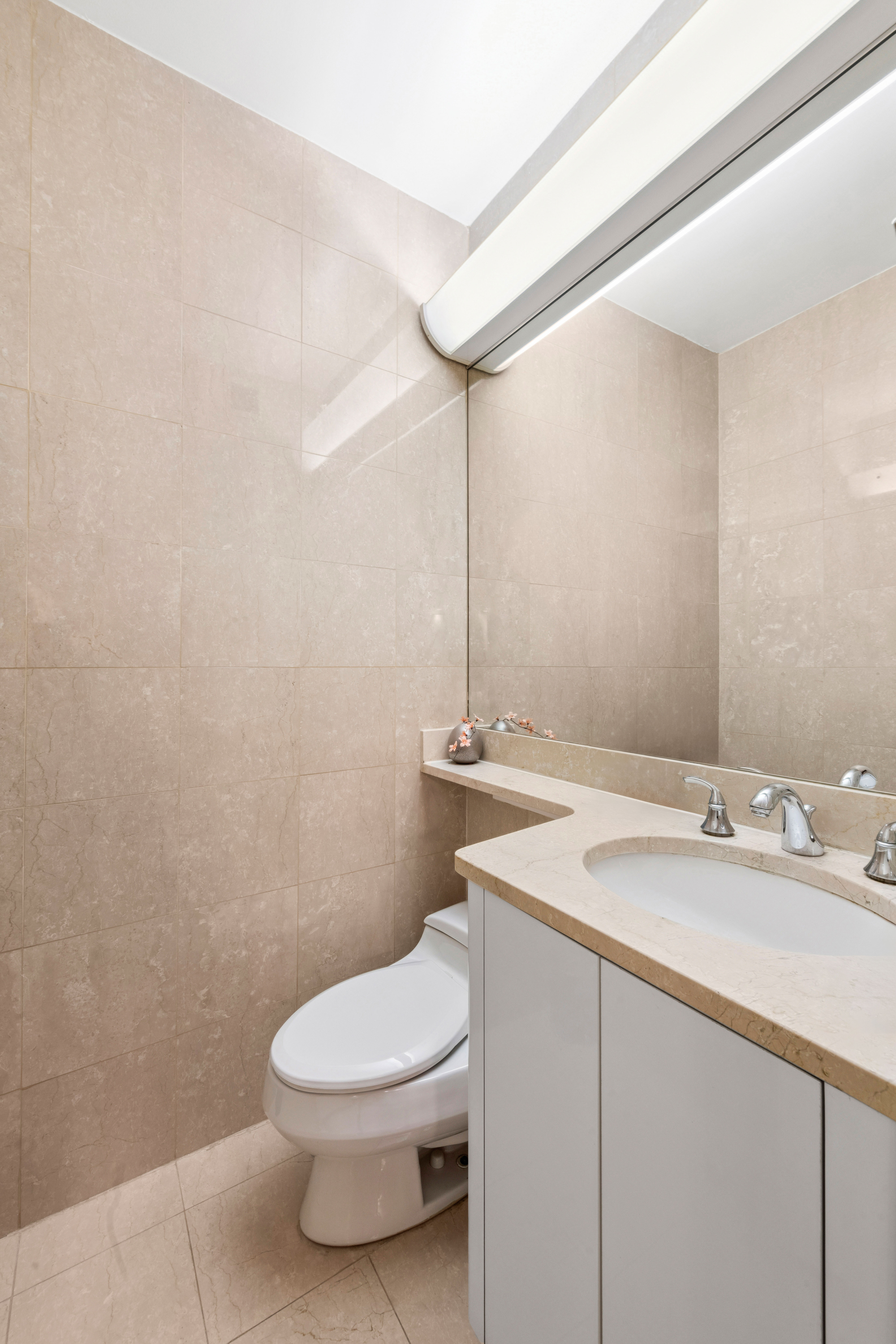 200 East 69th Street, Unit 4N Manhattan, NY 10021 - Photo 7 of 13 a bathroom with a granite countertop sink a toilet and mirror