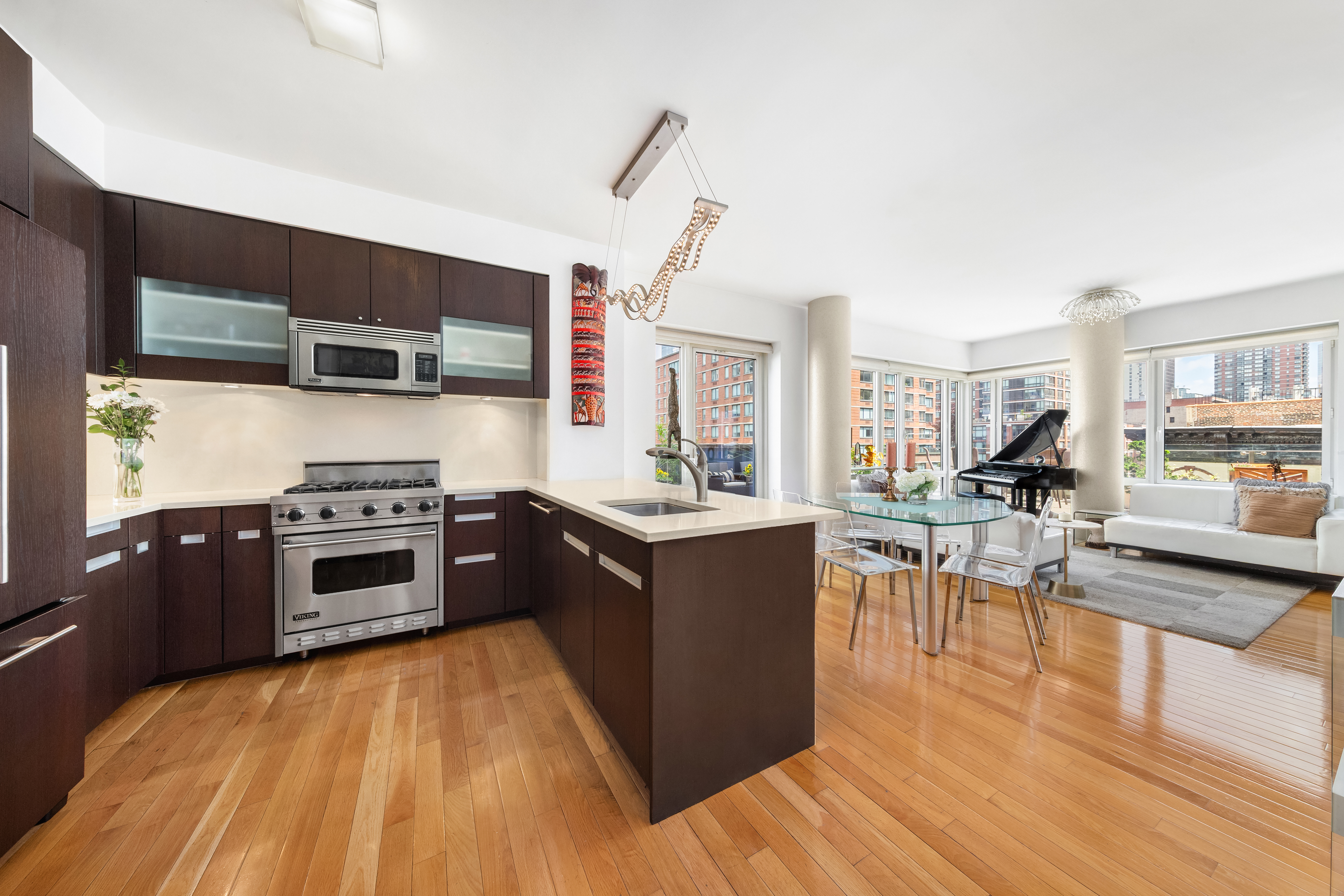 454 West 54th Street, Unit 7B Manhattan, NY 10019 - Photo 3 of 15 a kitchen with stainless steel appliances granite countertop a stove and a wooden floors