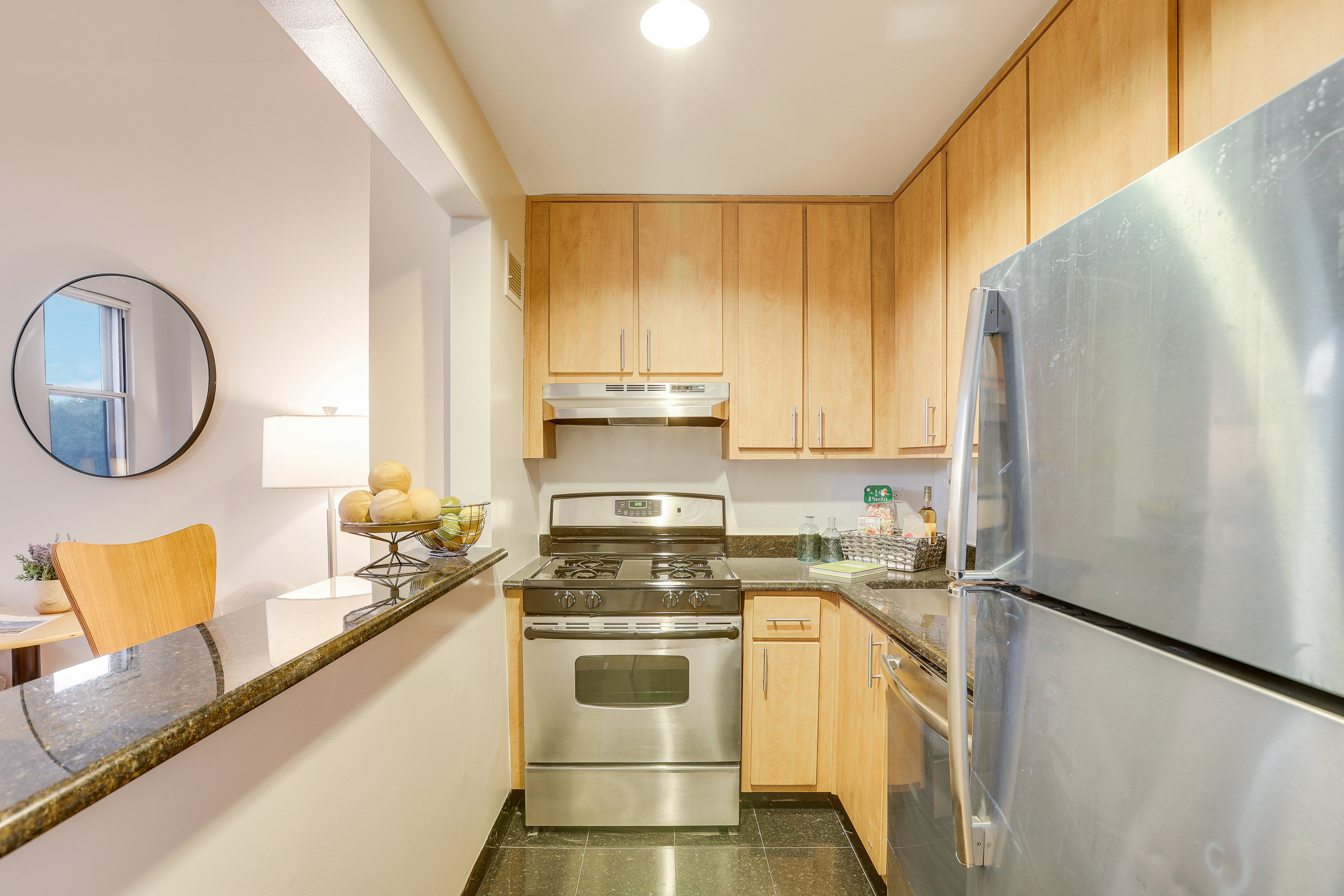 1255 5th Avenue, Unit 5B Manhattan, NY 10029 - Photo 8 of 12 a kitchen with stainless steel appliances granite countertop a stove a sink and a refrigerator