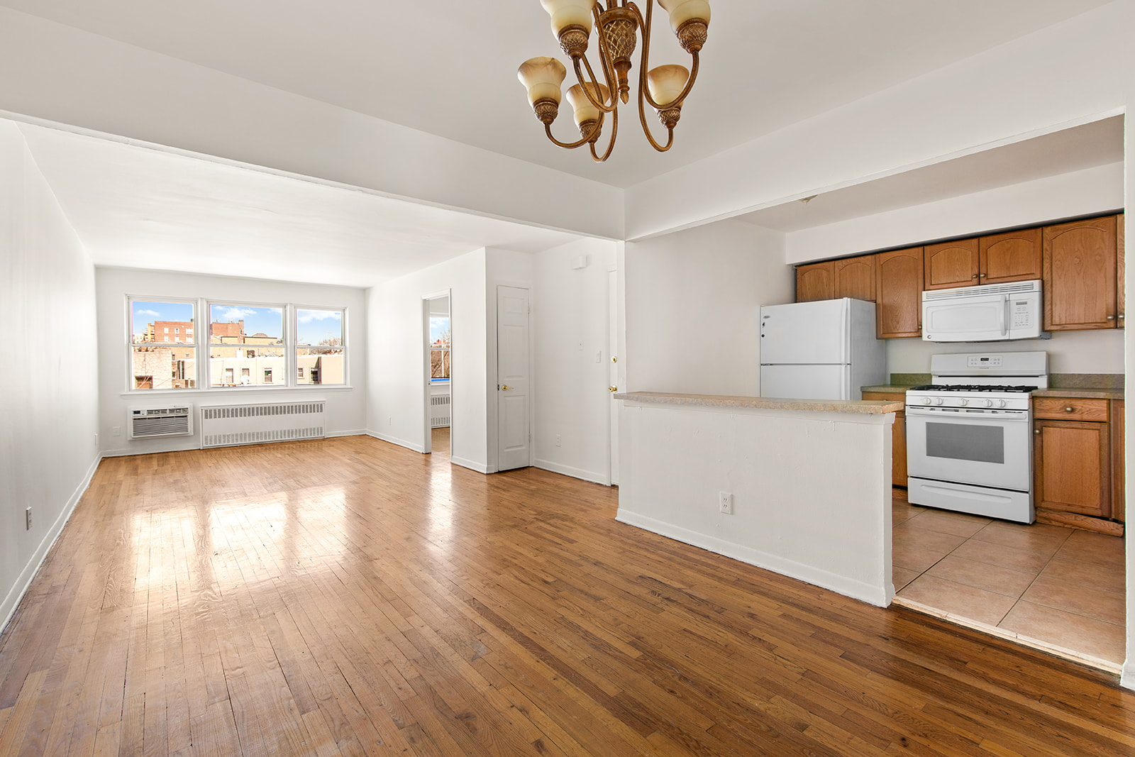 572 92nd Street Brooklyn, NY 11209 - Photo 13 of 20 a view of a kitchen with wooden floor electronic appliances and window