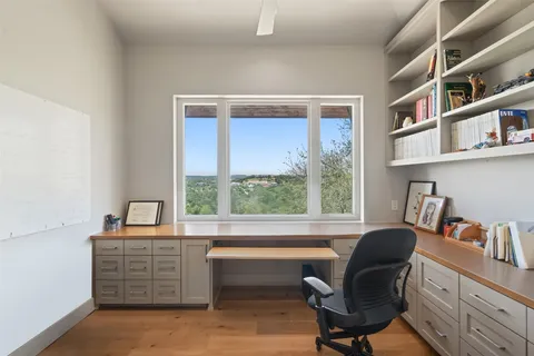 a view of a workspace with furniture and a window