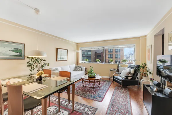 a living room with furniture large window and a table