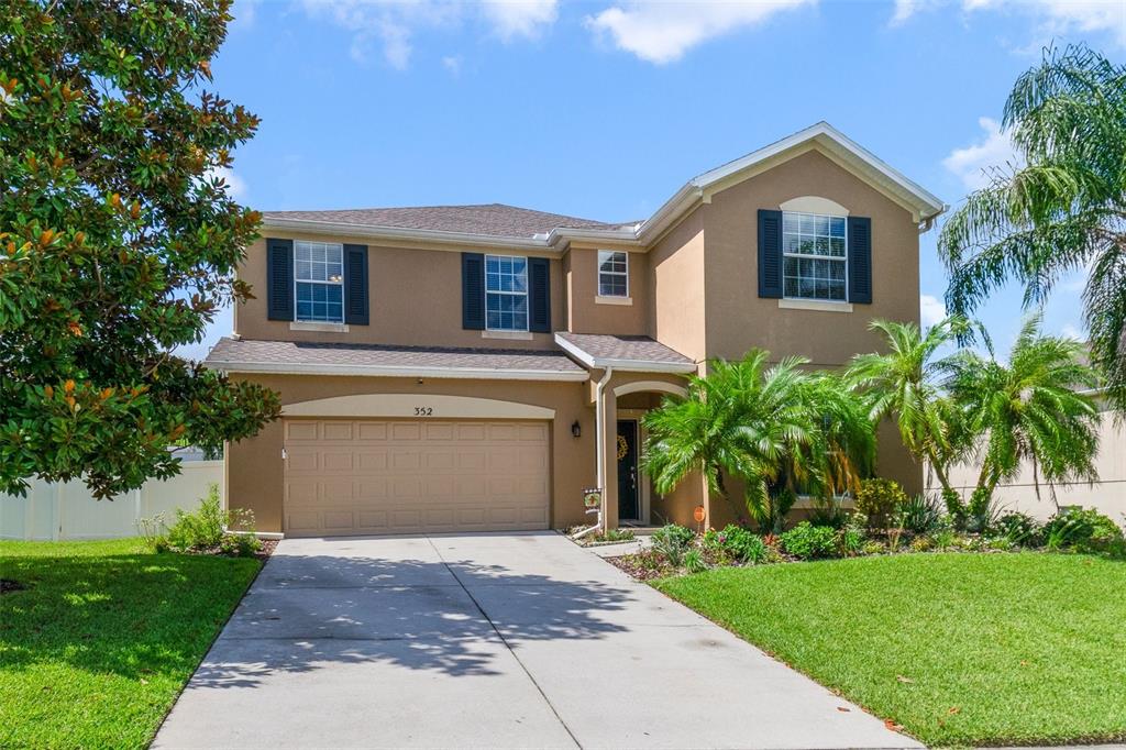 352 Giovani Boulevard Clermont, FL 34715 - Photo 45 of 46 a front view of a house with a garden and trees