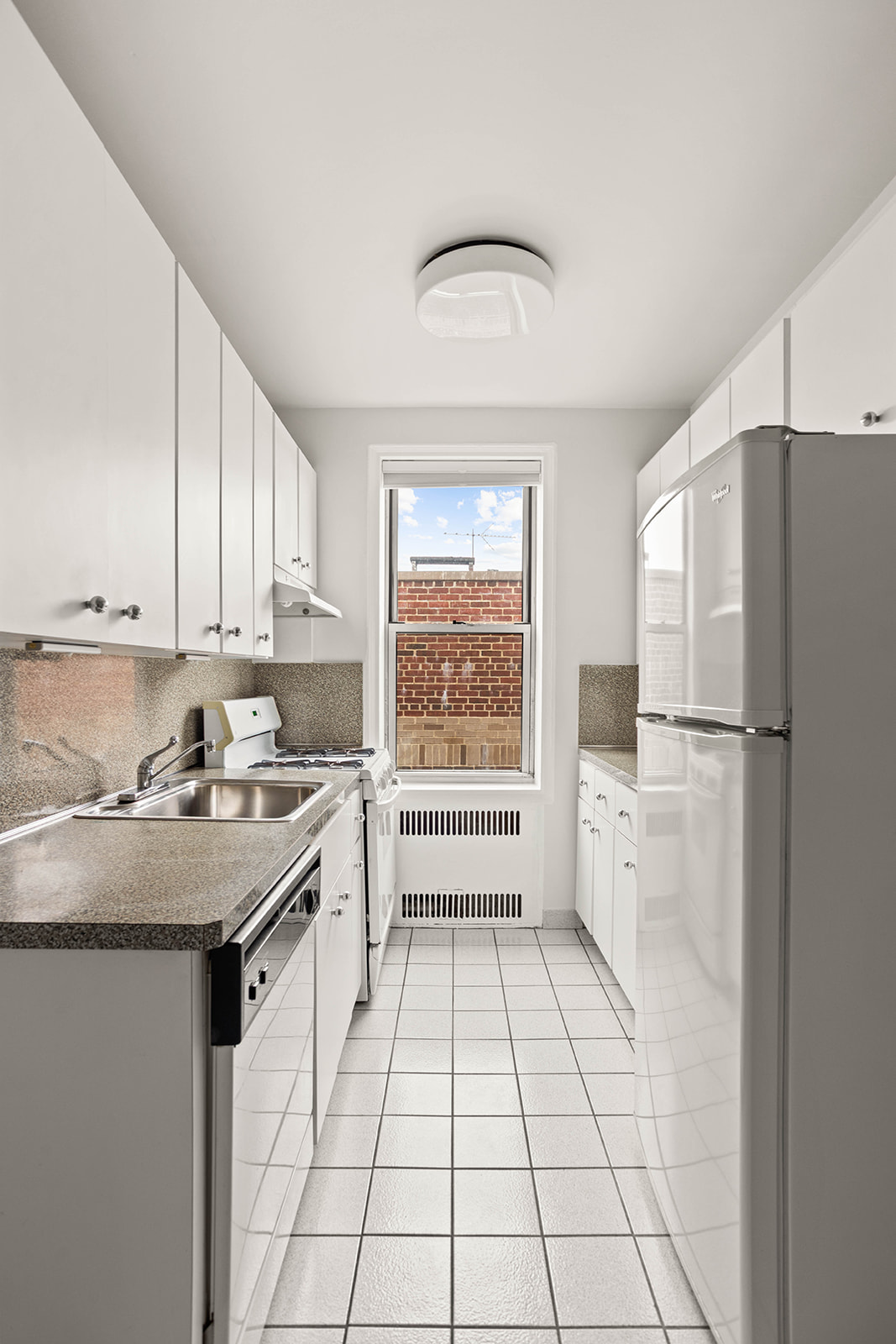 76-12 35th Avenue, Unit 6J Queens, NY 11372 - Photo 9 of 17 a kitchen with a refrigerator a stove a sink and cabinets