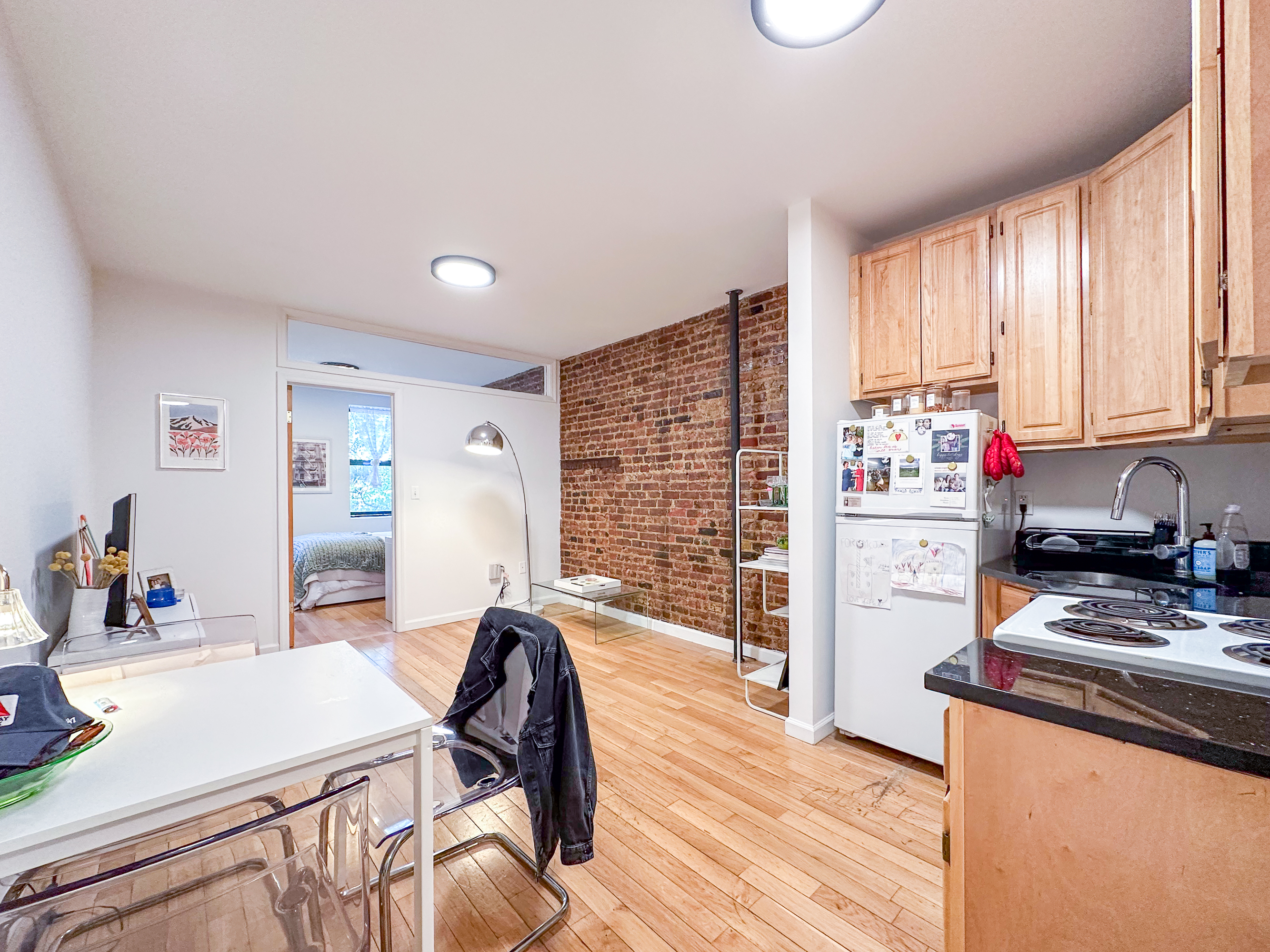 315 East 5th Street, Unit 5E Manhattan, NY 10003 - Photo 3 of 11 a kitchen with stainless steel appliances wooden floor dining table and chairs