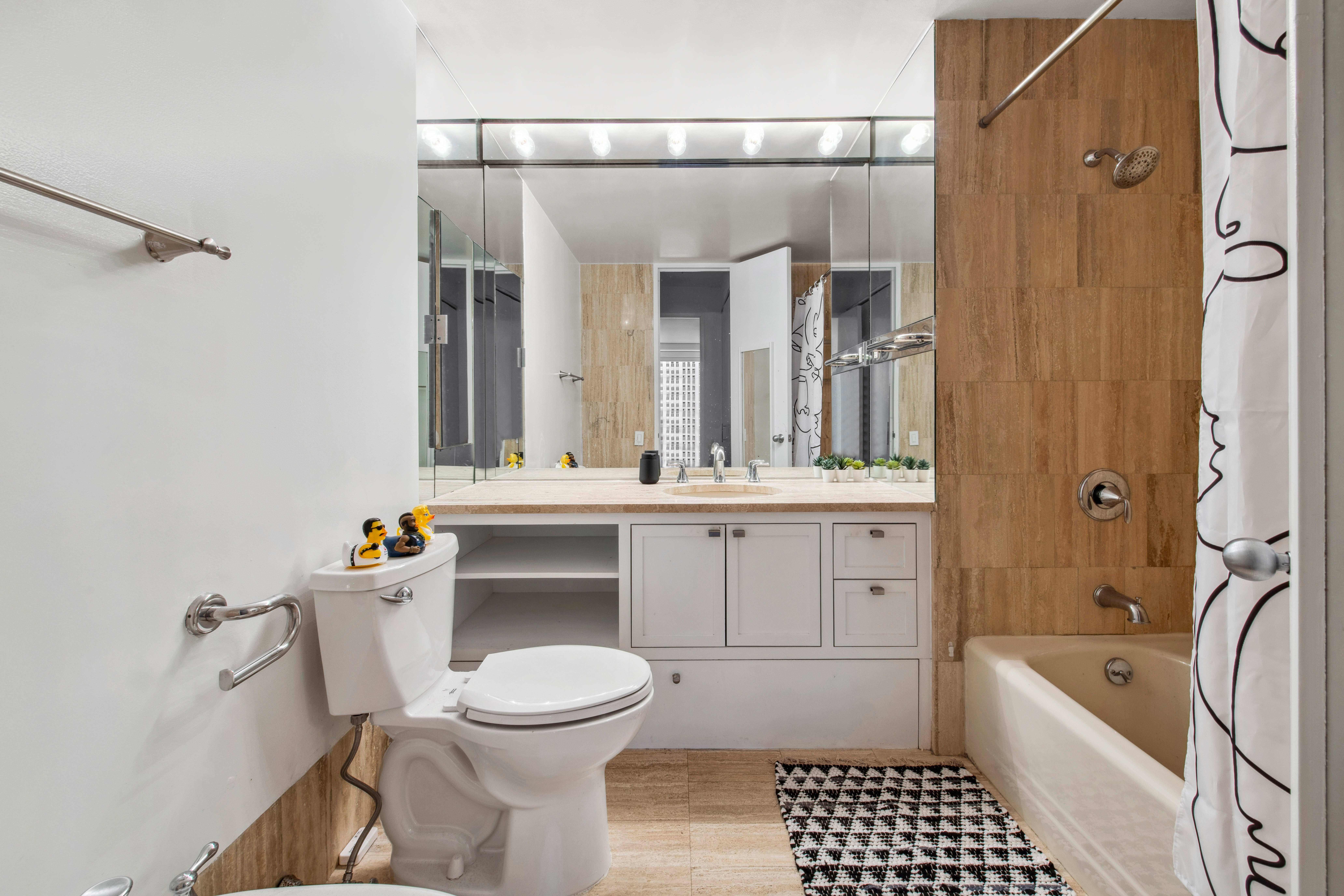 15 West 53rd Street, Unit 31C Manhattan, NY 10019 - Photo 7 of 14 a bathroom with a sink a toilet and shower
