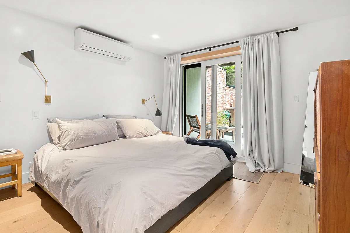87 Monroe Street, Unit 1 Brooklyn, NY 11216 - Photo 5 of 11 a bedroom with a bed and a large window