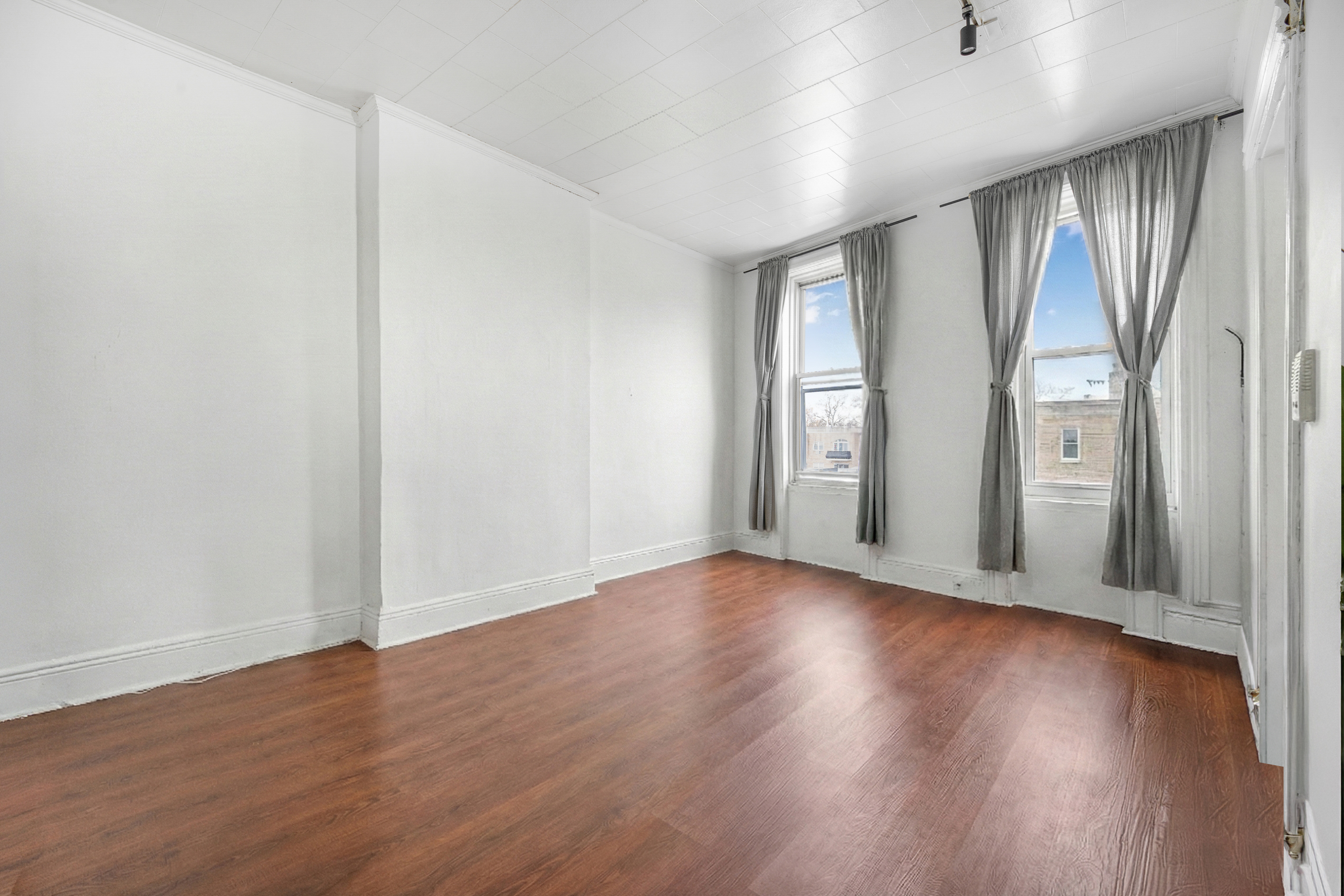 71-18 Myrtle Avenue Queens, NY 11385 - Photo 5 of 13 an empty room with wooden floor and windows