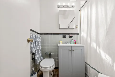 a bathroom with a sink toilet and a mirror