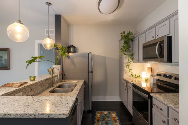 a kitchen with stainless steel appliances granite countertop a sink a stove and a refrigerator