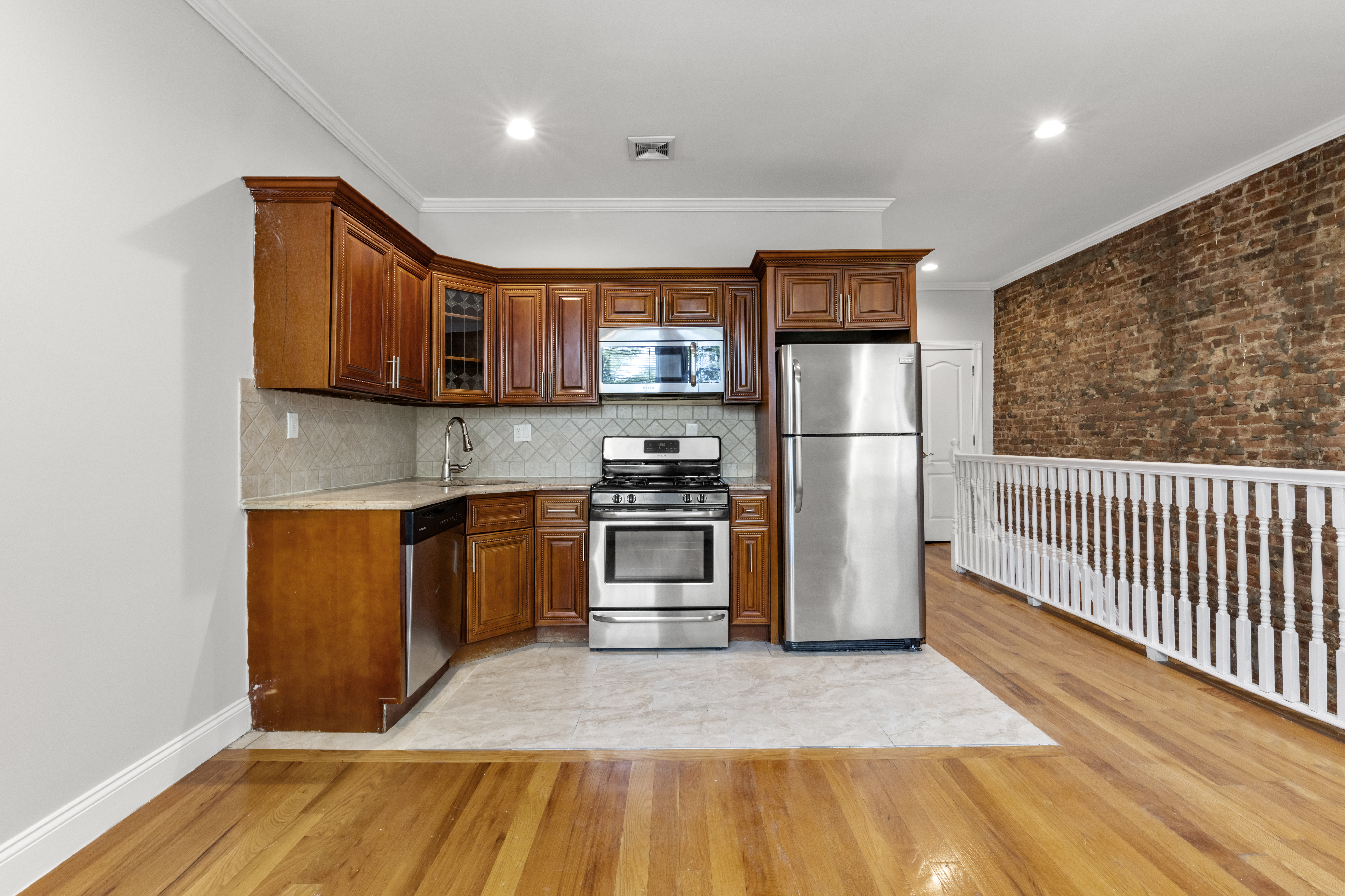 397 Bainbridge Street Brooklyn, NY 11233 - Photo 2 of 12 a kitchen with stainless steel appliances granite countertop a refrigerator and a sink