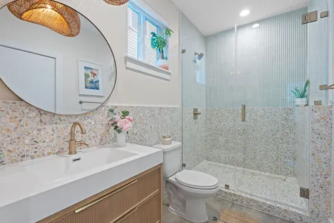 a bathroom with a sink a toilet and shower