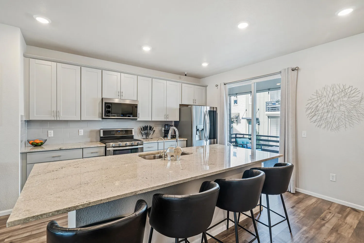 a kitchen with stainless steel appliances a stove a sink a microwave a refrigerator and cabinets