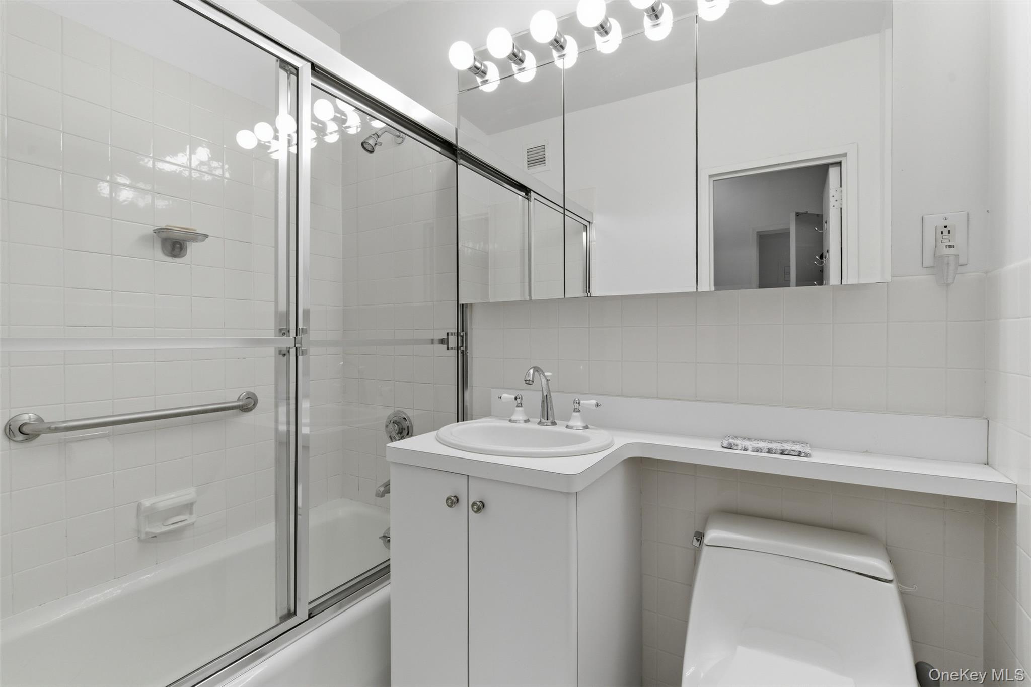 27110 Grand Central Parkway, Unit 26A Queens, NY 11005 - Photo 7 of 30 a bathroom with a sink a toilet and shower