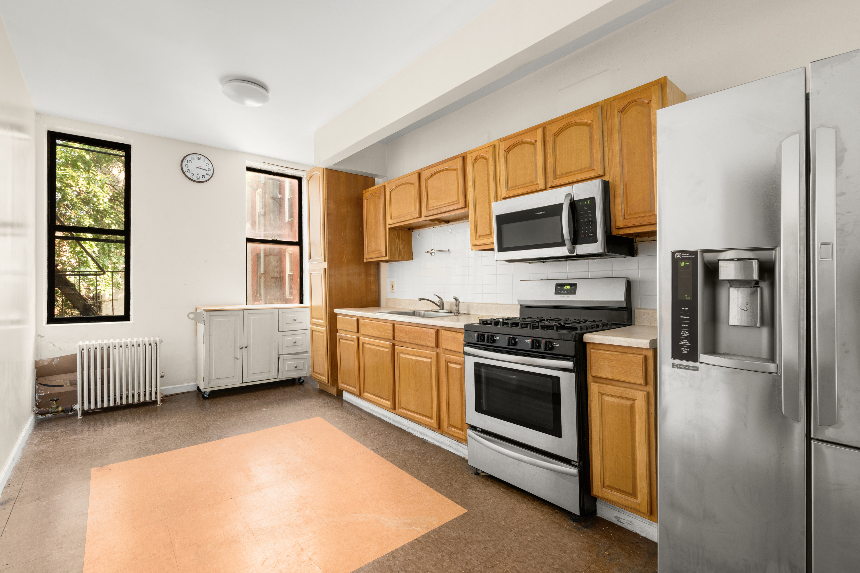 1098 Jefferson Avenue Brooklyn, NY 11221 - Photo 3 of 3 a kitchen with stainless steel appliances a stove a microwave and a refrigerator