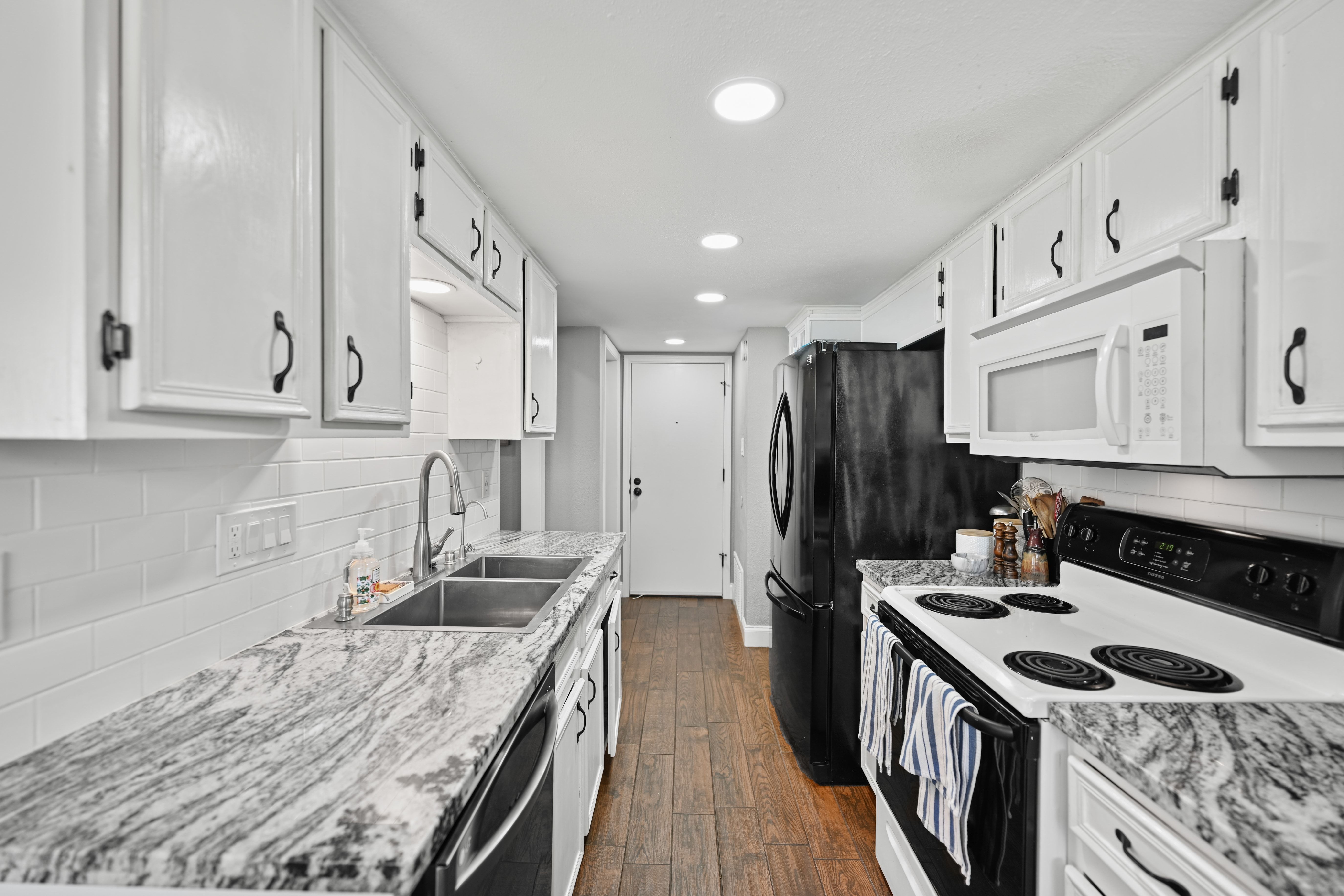 8710 Clearbrook Trail Austin, TX 78729 - Photo 3 of 28 a kitchen with granite countertop a sink stove and refrigerator