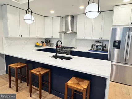 a kitchen with stainless steel appliances a sink a stove a refrigerator and cabinets