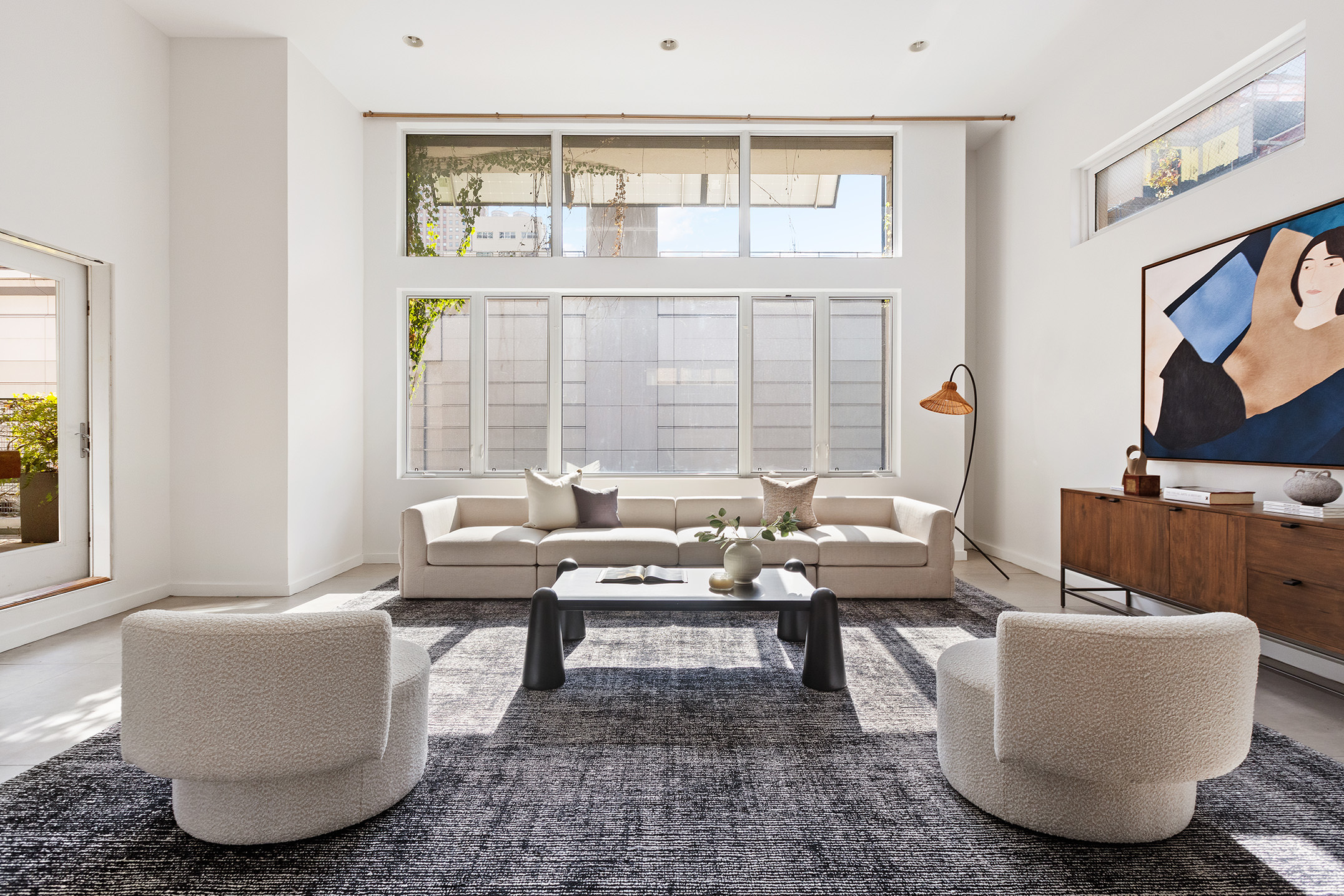 345 West 54th Street Manhattan, NY 10019 - Photo 3 of 22 a living room with couches a coffee table and a large window with outer view