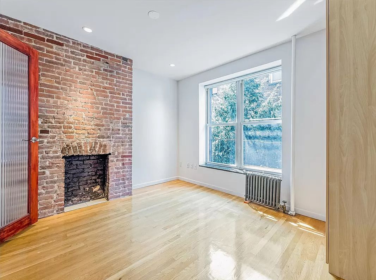 528 West 46th Street, Unit 3E Manhattan, NY 10036 - Photo 1 of 7 a view of an empty room with a window and fireplace