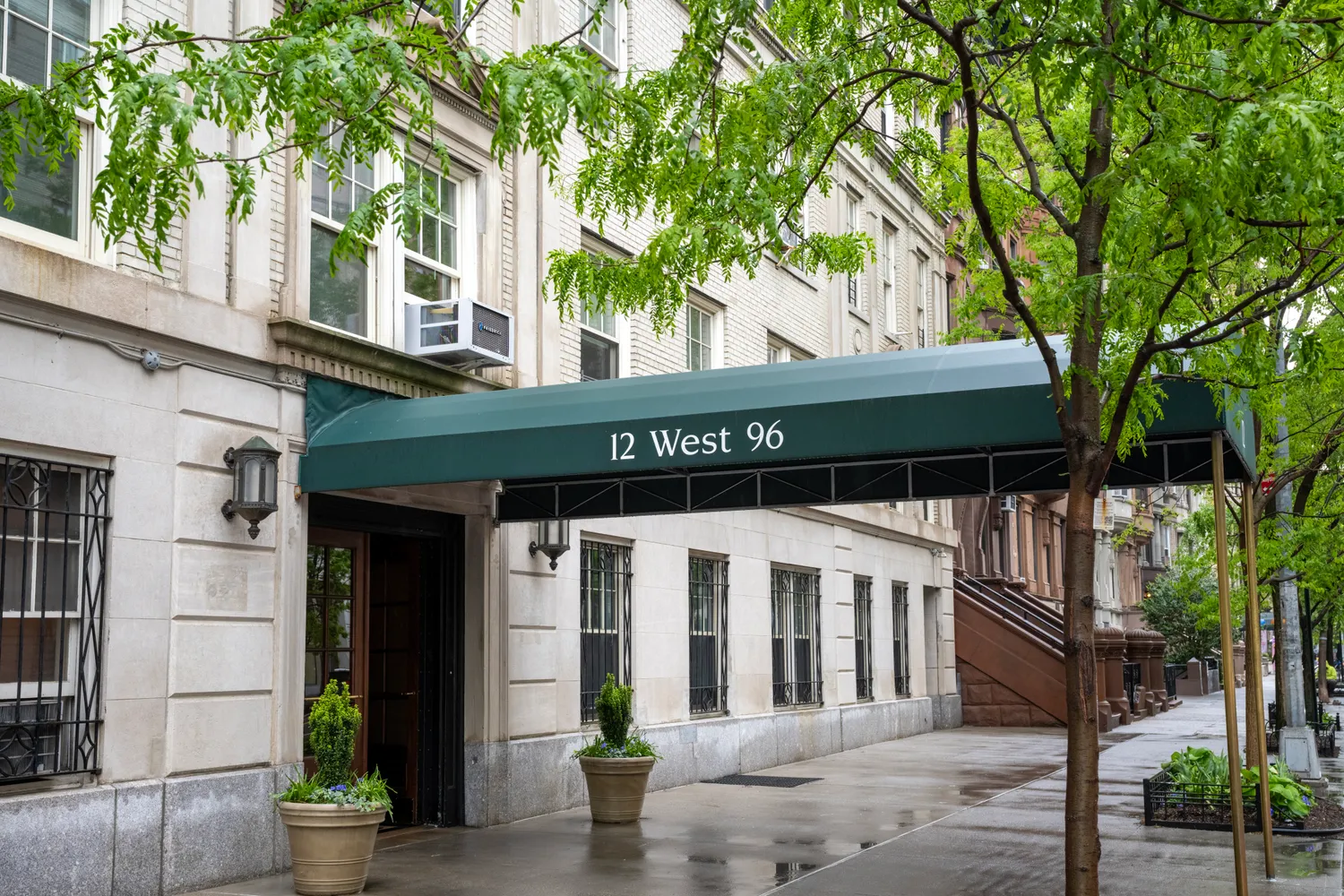 a front view of a house with a tree
