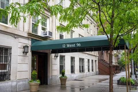 a front view of a house with a tree