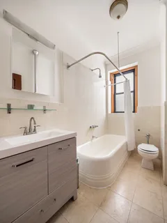 a spacious bathroom with a bathtub sink mirror and toilet