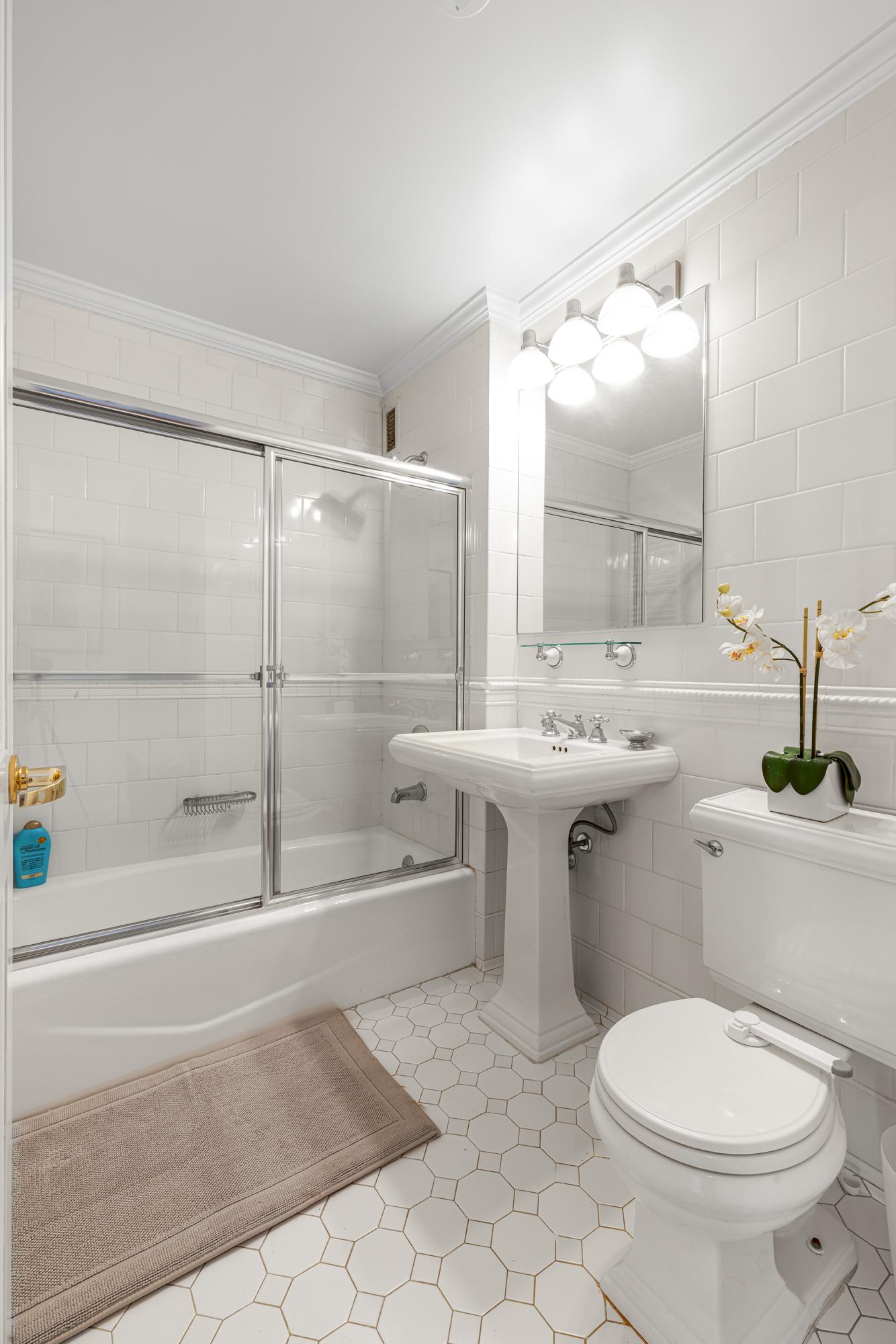404 East 76th Street, Unit 6K Manhattan, NY 10021 - Photo 8 of 12 a bathroom with a sink toilet and shower