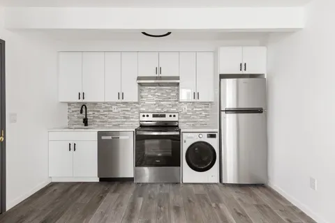 a kitchen with a stove top oven and white stainless steel appliances