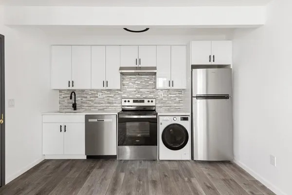 a kitchen with a stove top oven and white stainless steel appliances