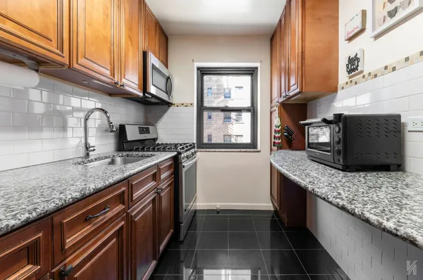 a kitchen with stainless steel appliances granite countertop a sink stove and cabinets