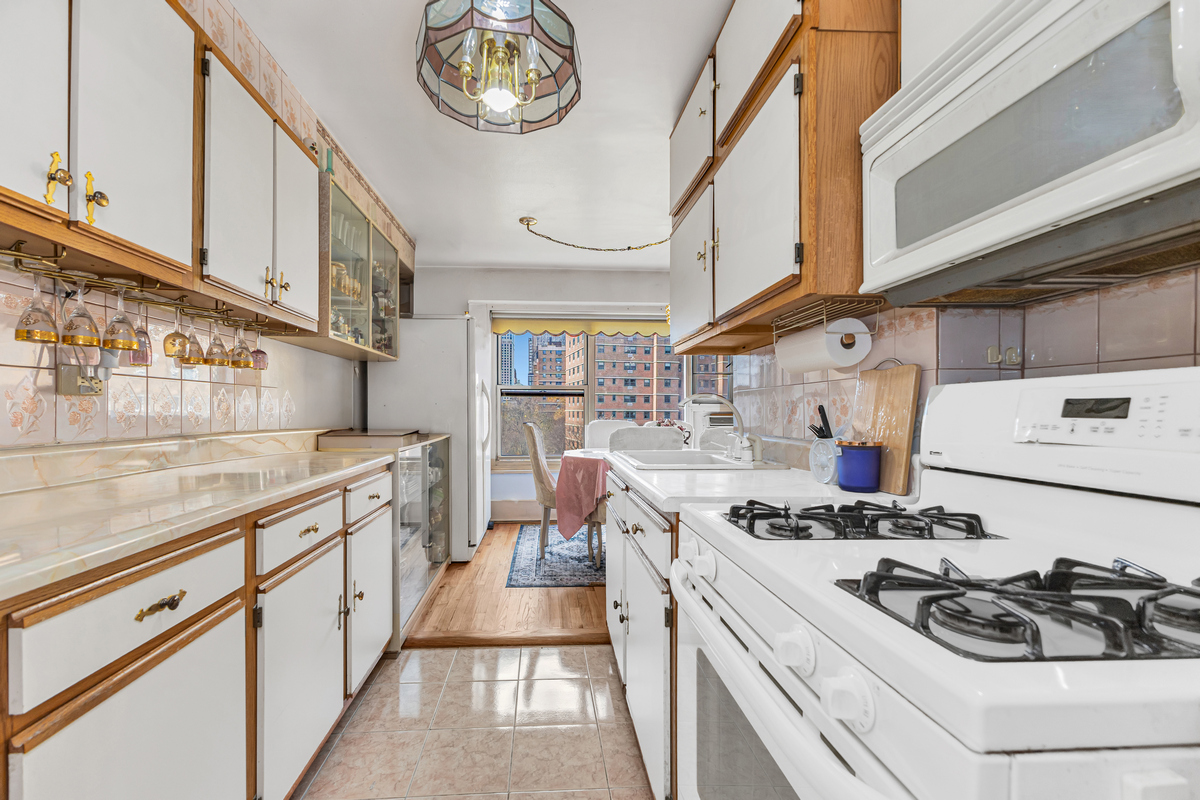 135 Ashland Place, Unit 8B Brooklyn, NY 11201 - Photo 7 of 11 a kitchen with a stove and a white cabinets