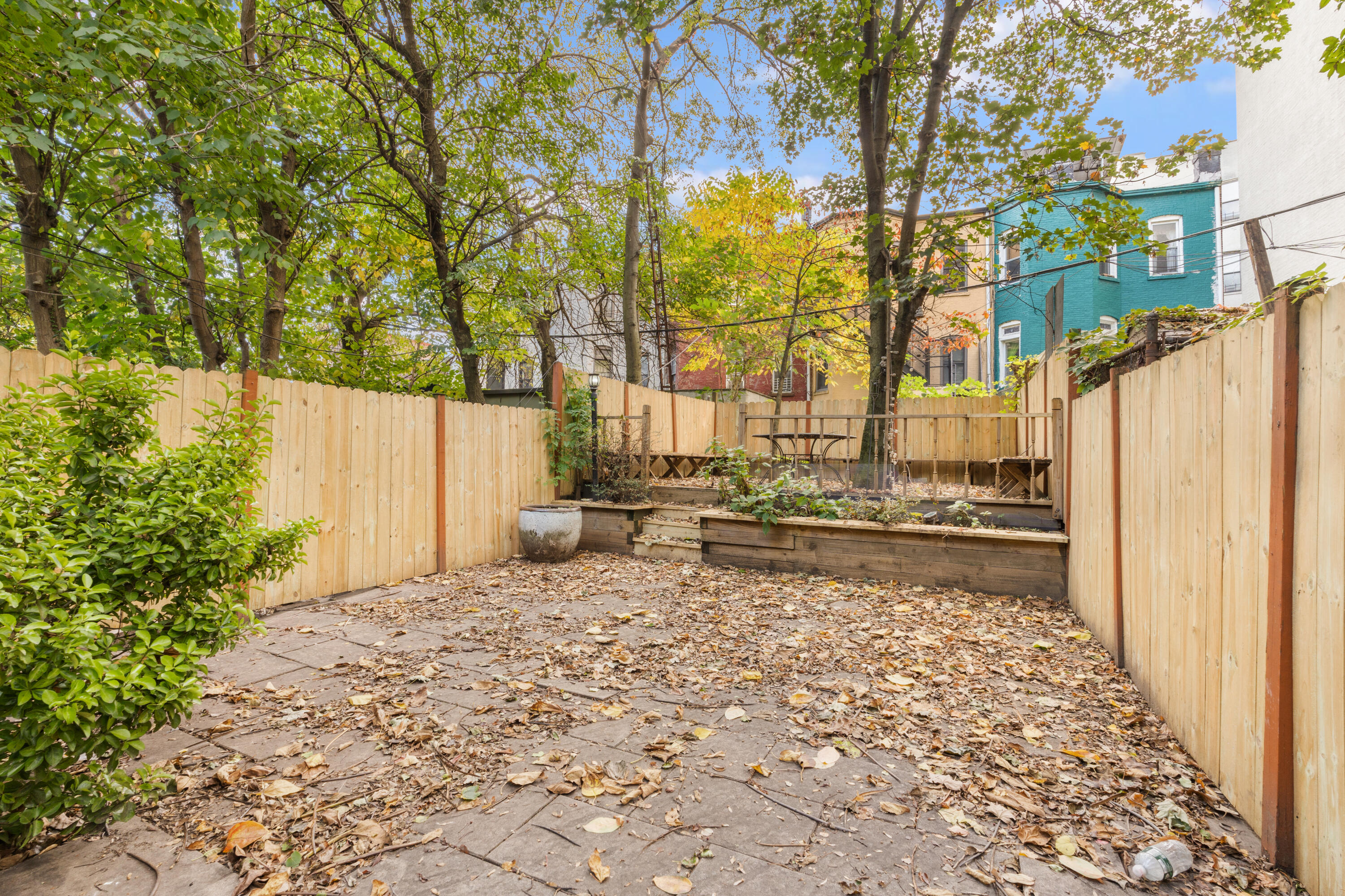 688 Saint Marks Avenue, Unit GARDEN Brooklyn, NY 11216 - Photo 9 of 13 a view of a backyard with table and chairs and a large tree