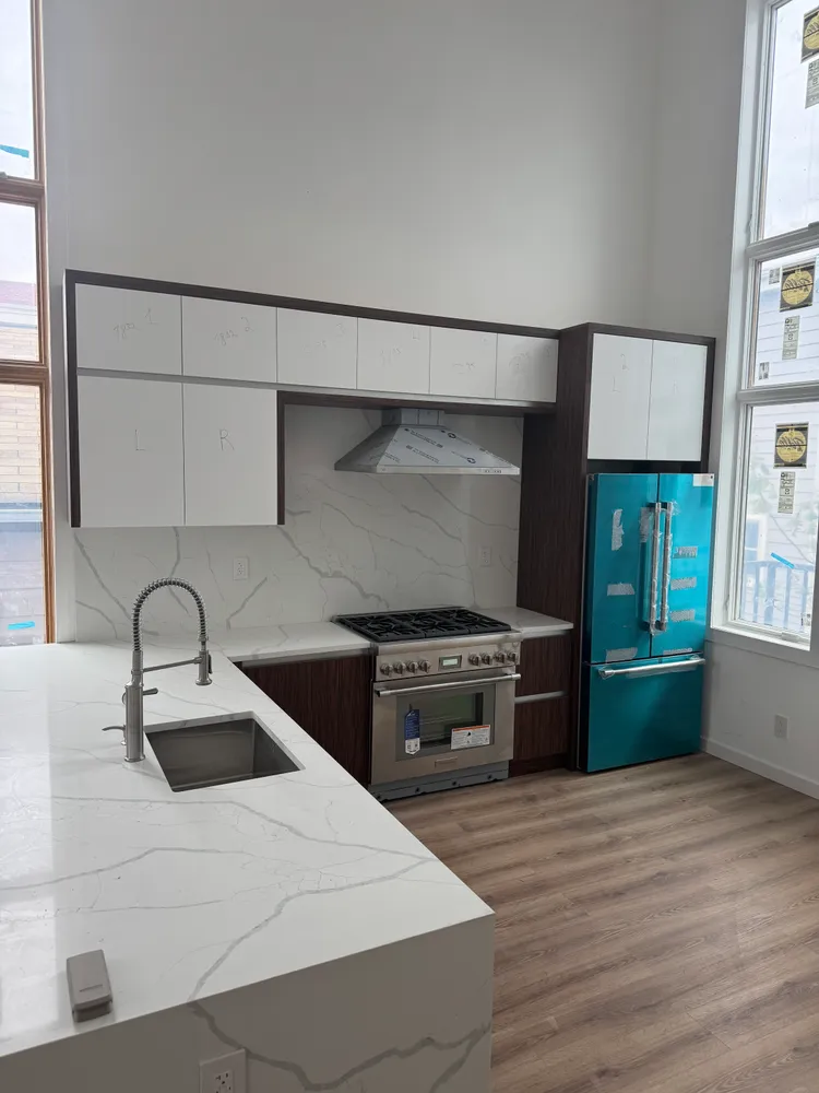 a kitchen with kitchen island granite countertop a sink cabinets and wooden floor