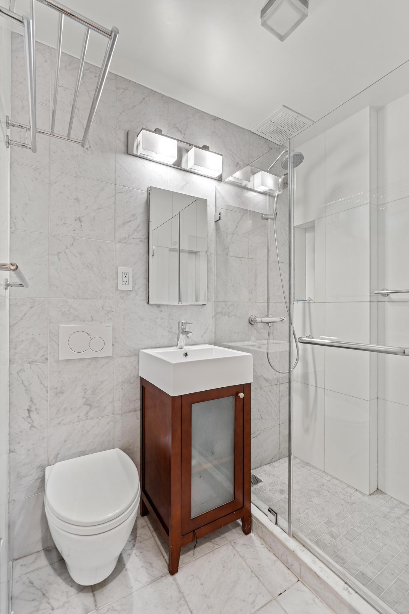 143 Sullivan Street, Unit 16 Manhattan, NY 10012 - Photo 6 of 10 a bathroom with a toilet sink and shower