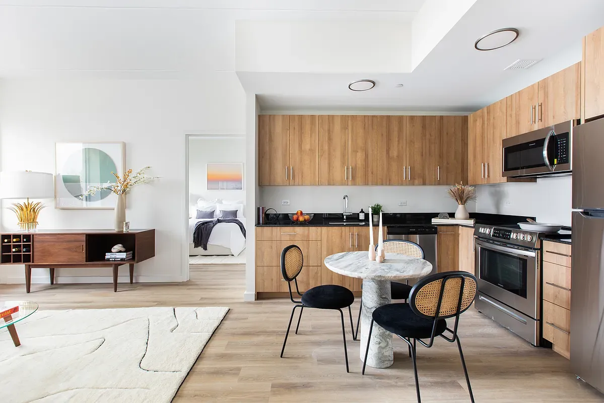 a kitchen with stainless steel appliances granite countertop a stove a sink a dining table and chairs