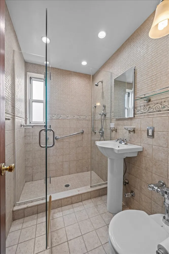 a bathroom with a sink a toilet and shower