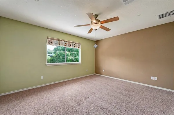 an empty room with a window and a fan