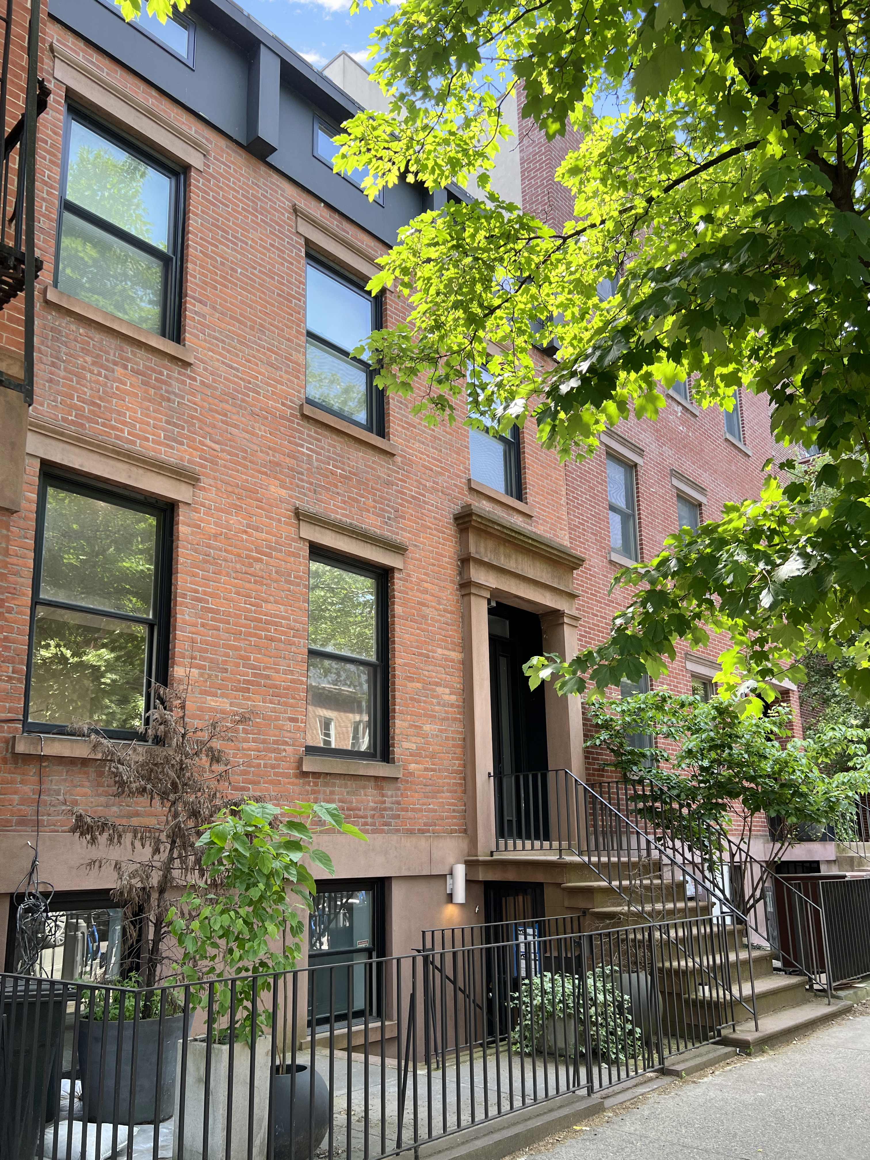 a front view of a house with a tree