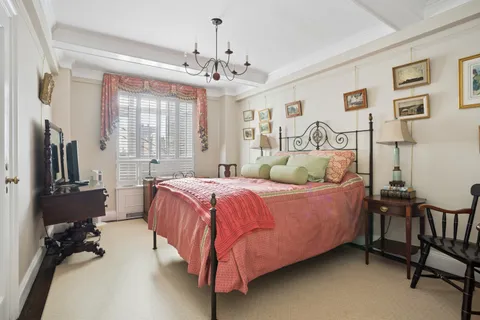 a spacious bedroom with a bed and a chandelier