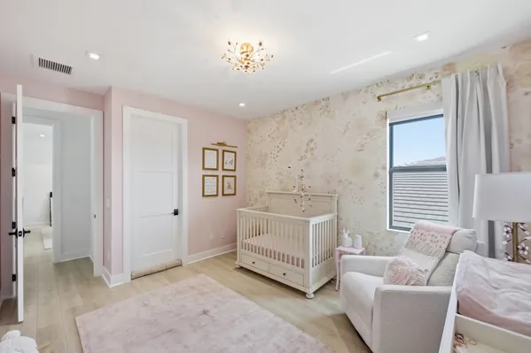a spacious bedroom with a bed and a lamp