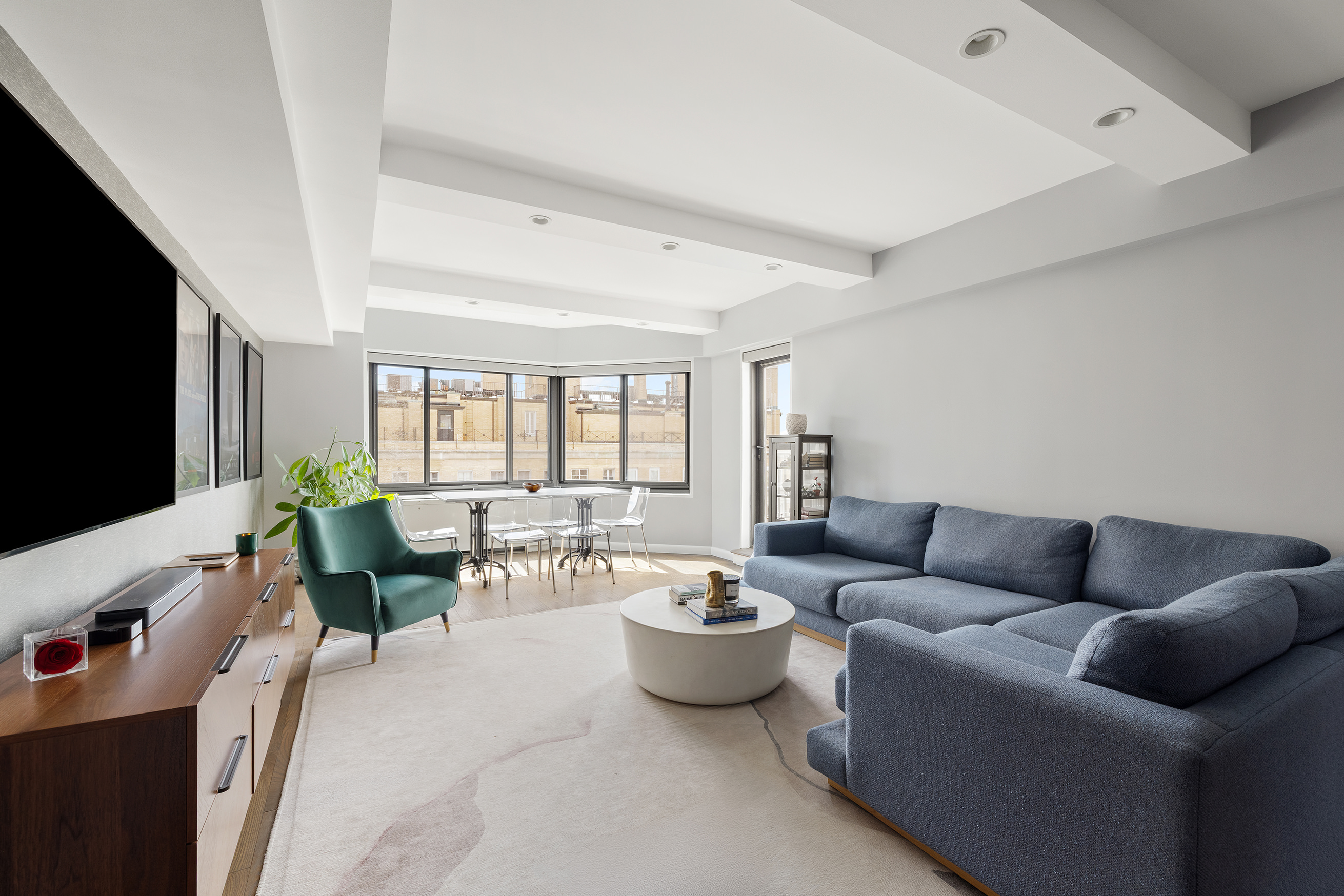 10 East End Avenue, Unit 18D Manhattan, NY 10075 - Photo 1 of 21 a living room with furniture and a flat screen tv