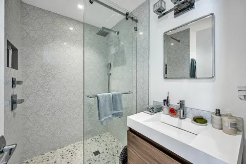 a bathroom with a sink a shower and a mirror