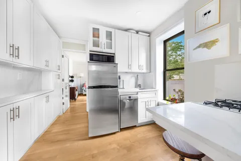 a kitchen with white cabinets and appliances