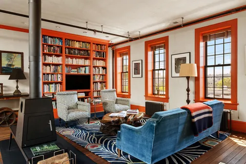 a living room with furniture a flat screen tv and a floor to ceiling window
