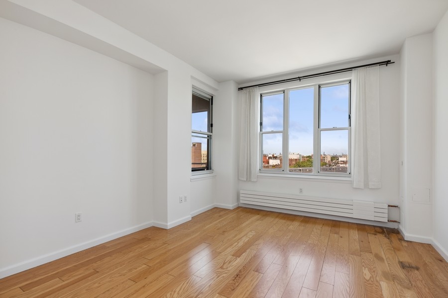 50 Oceana Drive West, Unit 5G Brooklyn, NY 11235 - Photo 8 of 12 an empty room with wooden floor and windows