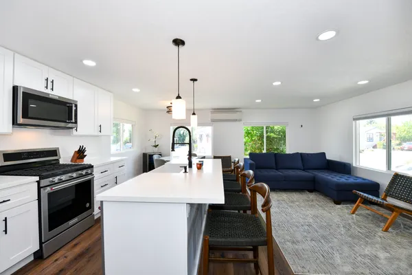 a living room with furniture a flat screen tv and kitchen view