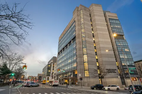 a front view of a building with trees