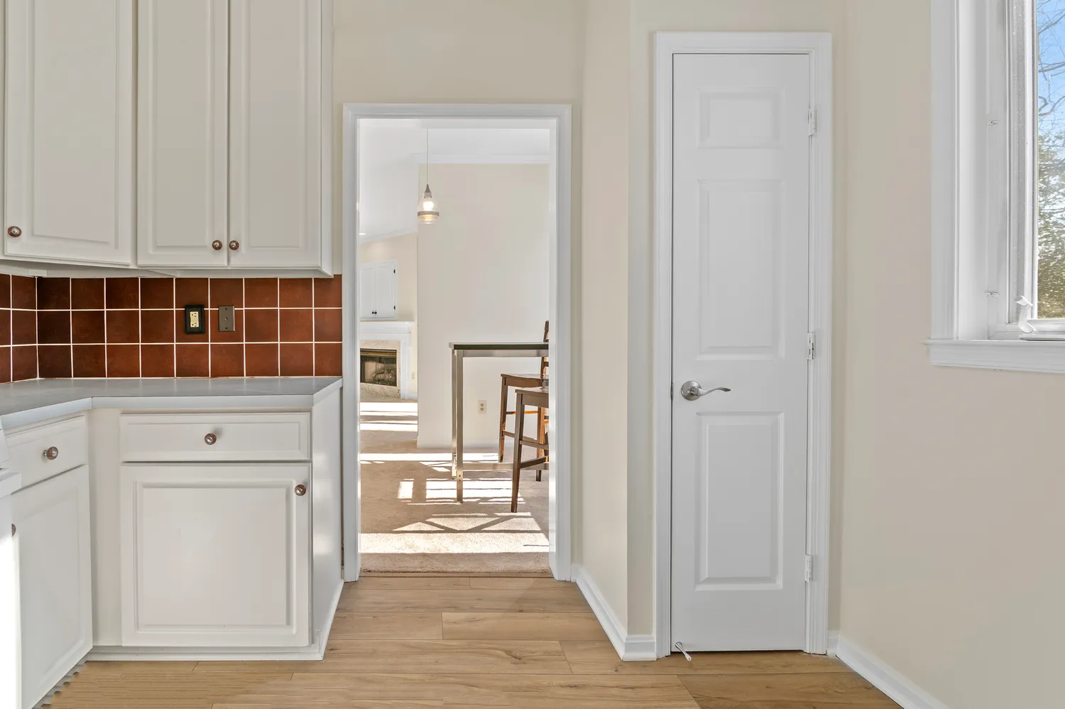 a kitchen with white cabinets and sink
