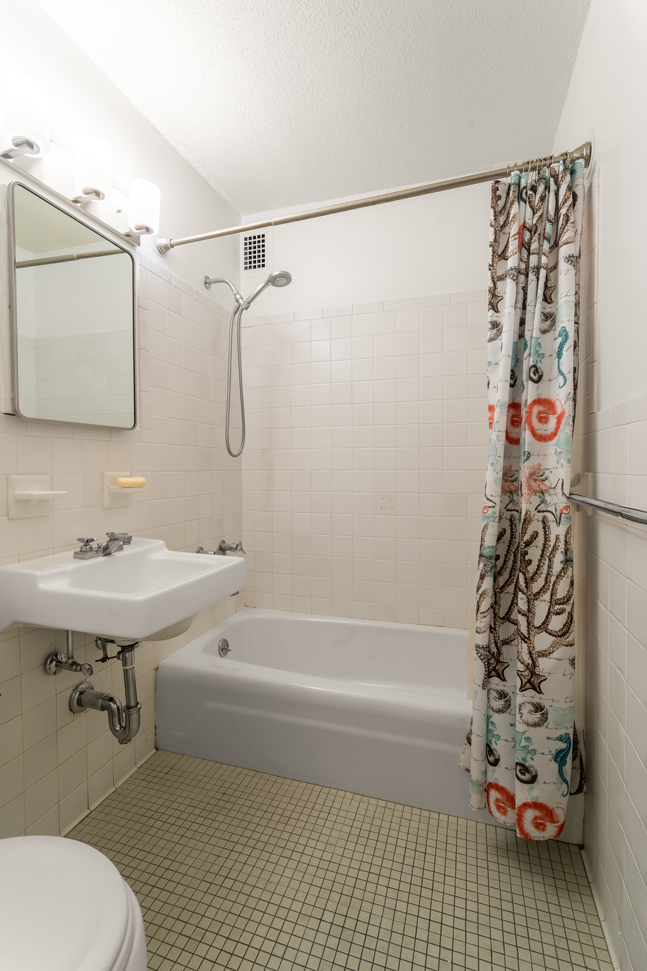 77 Fulton Street, Unit 18G Manhattan, NY 10038 - Photo 7 of 8 a bathroom with a sink a toilet and shower